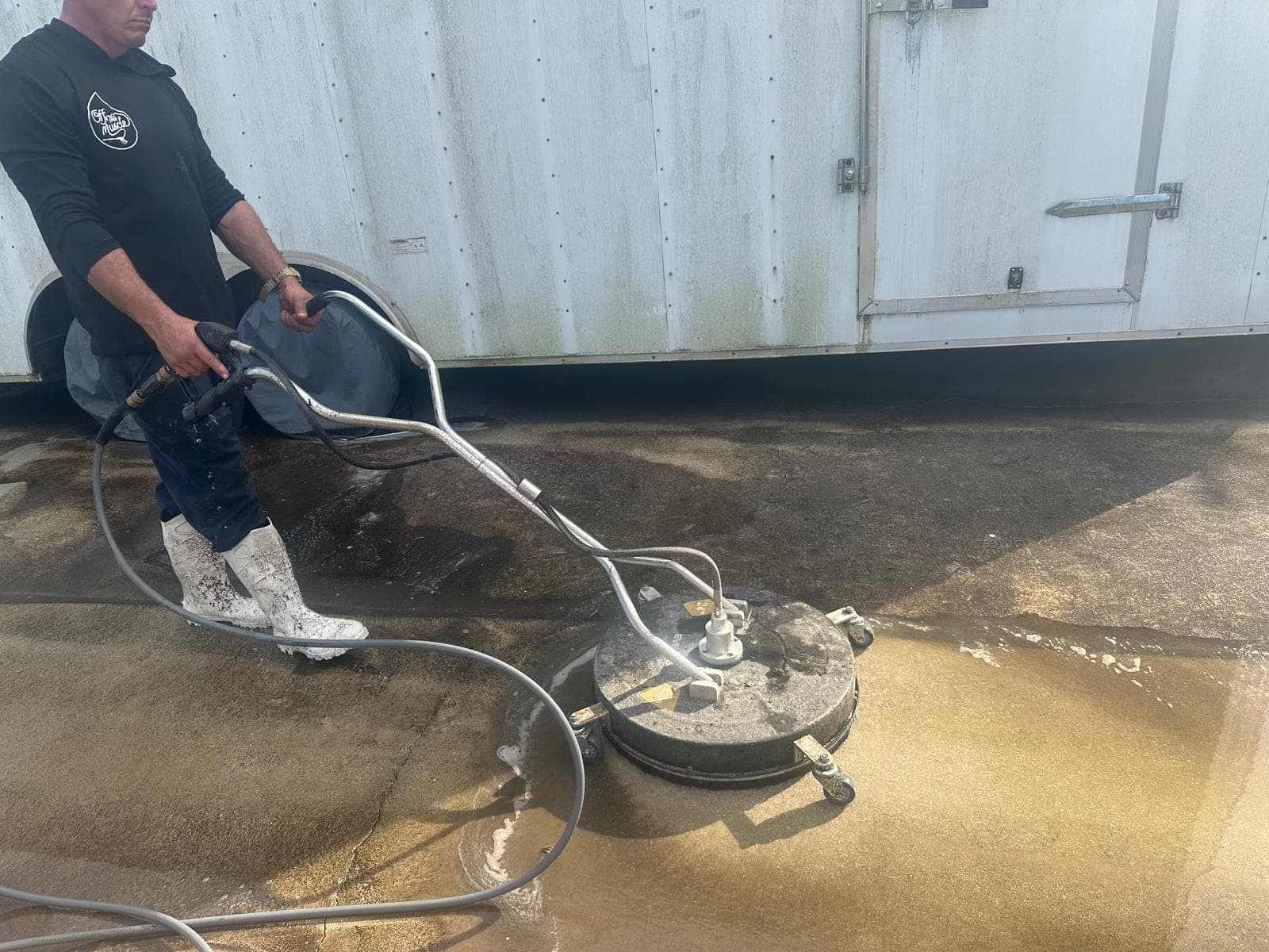 Surface cleaner cutting a clean path across a dirty South Florida driveway